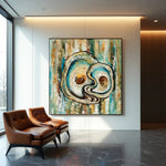Abstract painting of a yin and yang symbol in a modern interior setting with leather chairs.