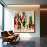 Bloom in Motion expressive abstract painting with forest green, red and gold accents beside modern leather chairs