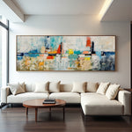 Skyline in Silence textured abstract painting with pale layers and colourful architectural forms above a sectional sofa